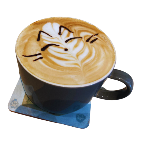 Image shows a coffee in a dark grey mug on a coaster. The coffee is decorated with latte art and a cat face with whiskers drawn on the top of it.